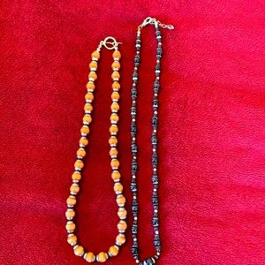 Two necklaces - one black and silver, the other copper and silver.